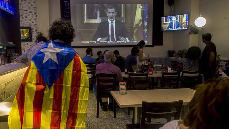 Varias personas miran en televisión en un bar en Barcelona el discurso del rey Felipe VI tras el referendum del 1-O. EFE/QUIQUE GARCÍA