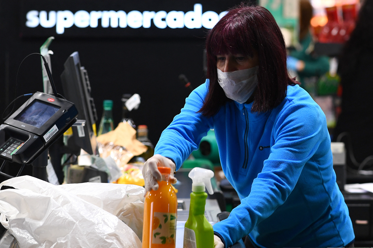 Una mujer durante su jornada laboral como trabajadora esencial en un supermercado de Madrid el 17 de marzo de 2020. GABRIEL BOUYS / AFP