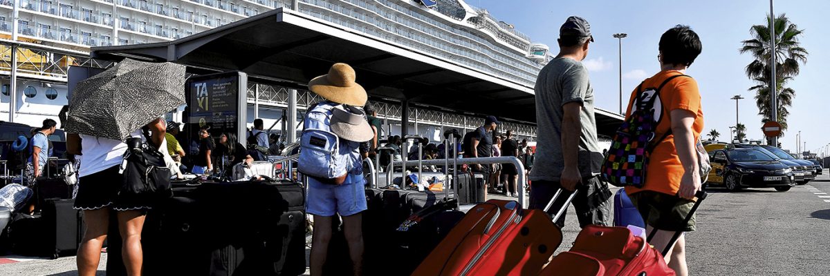 Cruceristas esperando a los taxis después de desembarcar del crucero 'Wonder of the Seas' en el puerto de Barcelona, el24 de julio de 2022.- PAU BARRENA/AFP